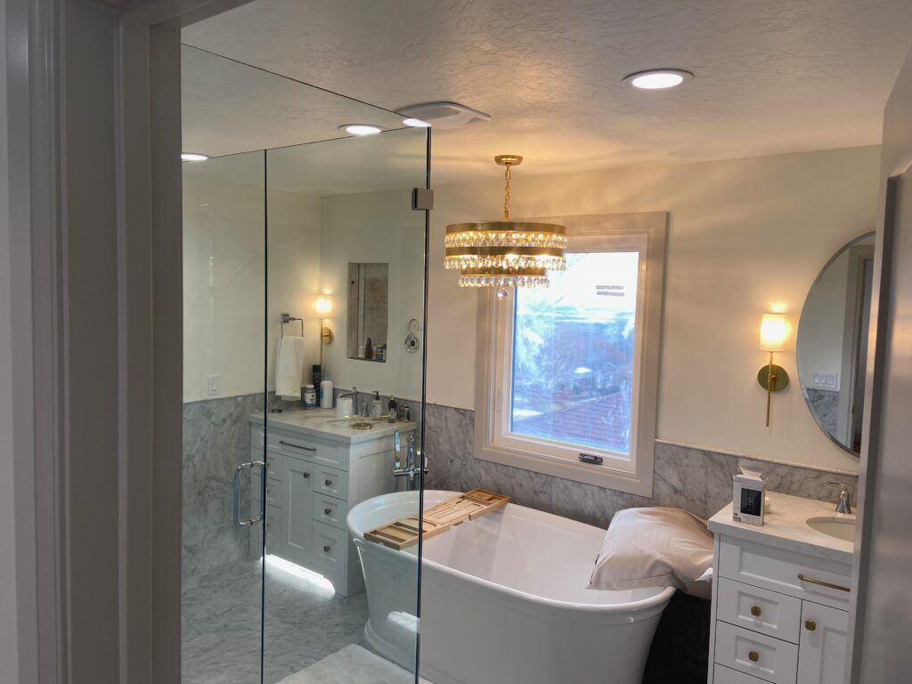 Bathroom with sconce lights and chandelier